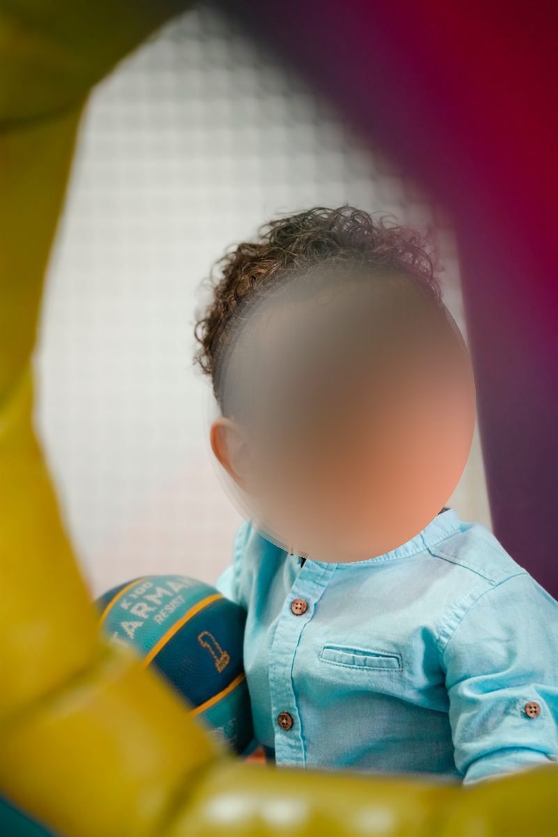 Retrato de un niño pequeño con camisa azul mirando a un lado